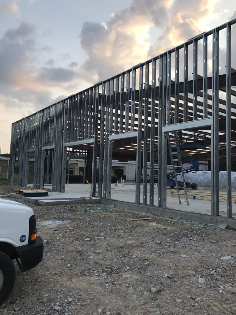 Steel framework of a building under construction at dusk.