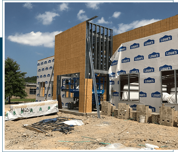 Construction site of a modern building with glass and wood elements.