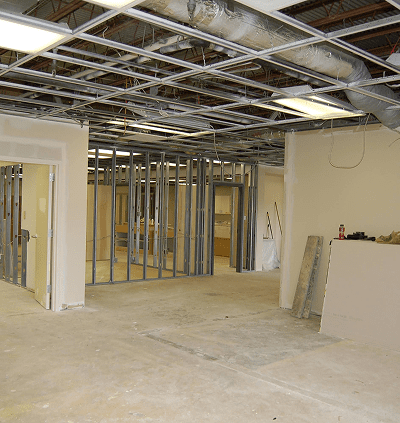Interior of a building under renovation with exposed ceiling and metal framing.