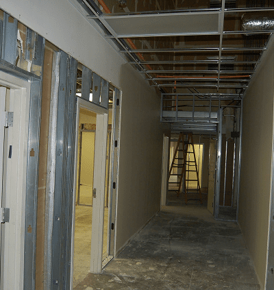 Hallway under construction with exposed ceiling and metal framing.