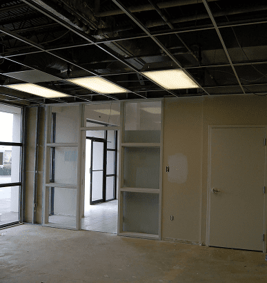 An unfinished room with exposed ceiling and built-in shelves.